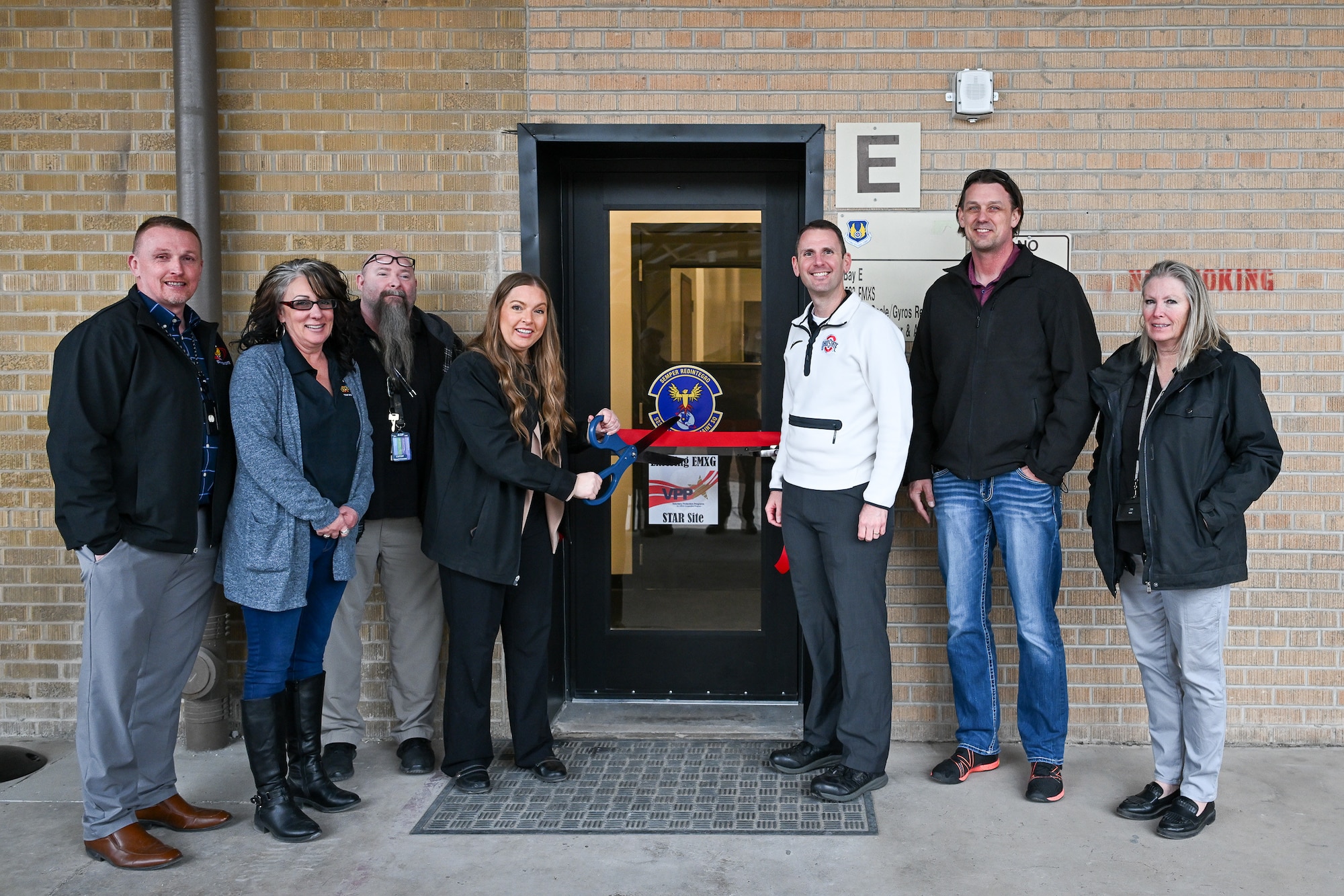Workers from the 309th Electronics Maintenance Group recently gathered for a ribbon cutting ceremony to celebrate the opening of Building 5’s Bay E, which recently underwent dramatic renovations and modernization.