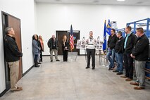Workers from the 309th Electronics Maintenance Group recently gathered for a ribbon cutting ceremony to celebrate the opening of Building 5’s Bay E, which recently underwent dramatic renovations and modernization.