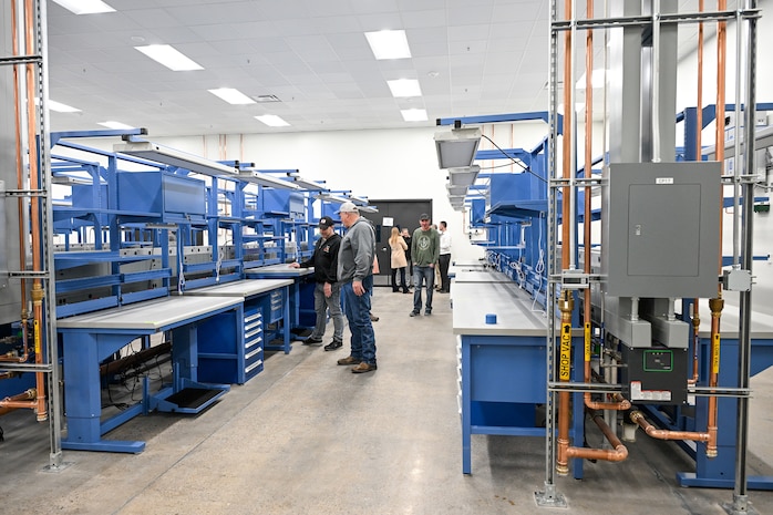 Workers from the 309th Electronics Maintenance Group recently gathered for a ribbon cutting ceremony to celebrate the opening of Building 5’s Bay E, which recently underwent dramatic renovations and modernization.