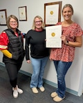 Three Munson employees showing of a certificate of a Gold Seal of Approval from The Joint Commission