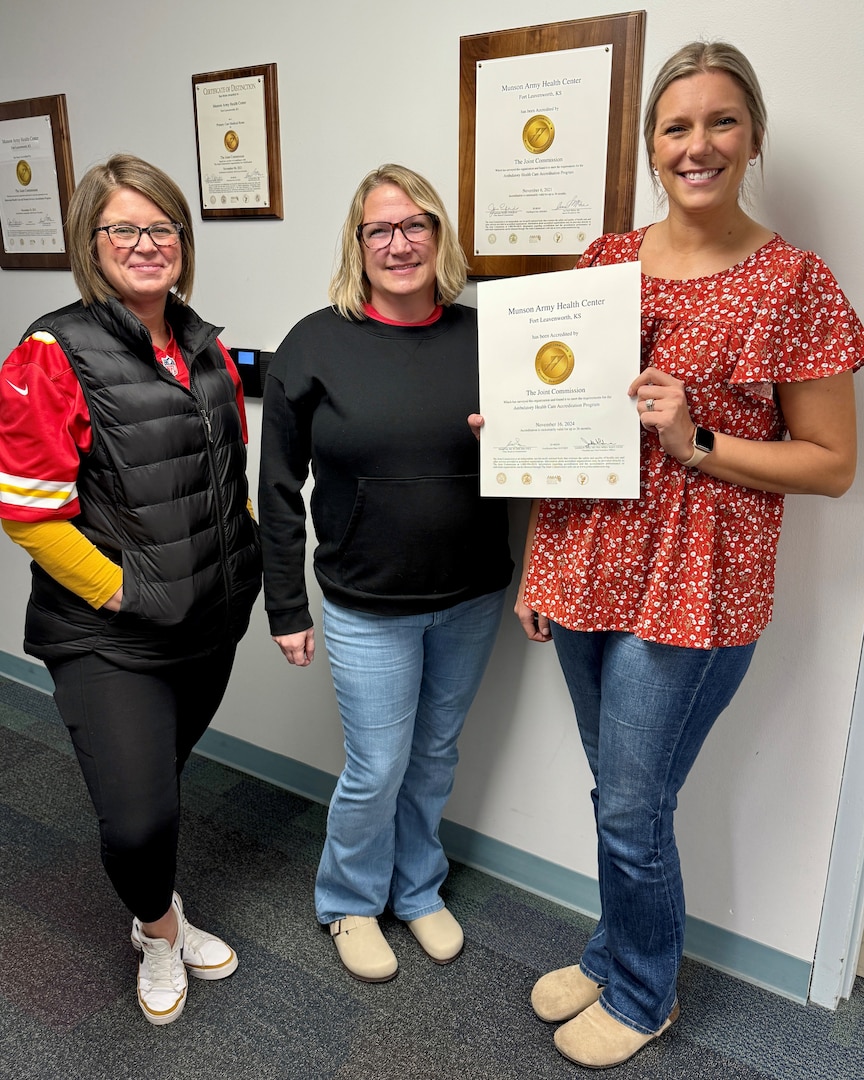 Three Munson employees showing of a certificate of a Gold Seal of Approval from The Joint Commission