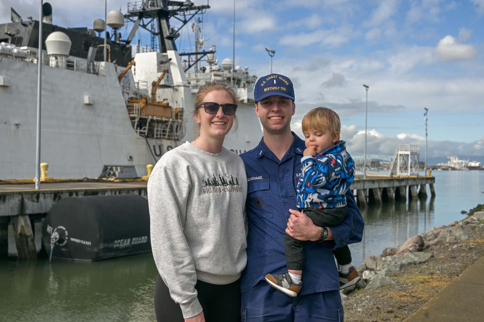 Lt. j.g. grade Benjamin Glashagel, poses with his family in front of United States Coast Guard Cutter Bertholf (WMSL 750) after the cutter and crew returned to their Alameda, California, home port following a 130-day Bering Sea patrol, Feb. 7, 2025.  Bertholf routinely conducts operations throughout the Pacific, strengthening U.S. presence along the maritime boundary line. (U.S. Coast Guard photo by Petty Officer 3rd Class Austin Wiley.)