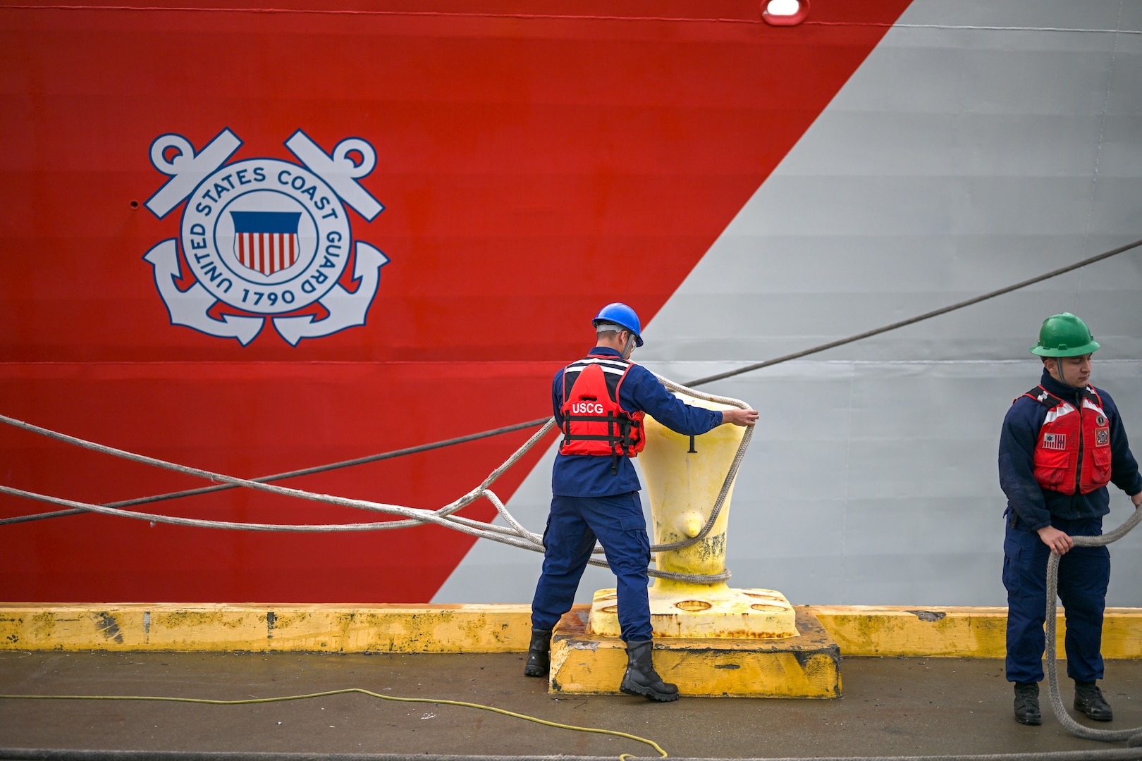 Line handlers secure mooring lines as the United States Coast Guard Cutter Bertholf (WMSL 750) returns to Alameda, California, Feb. 7, 2025. Bertholf’s crew provided search and rescue coverage of the Bering Sea showcasing the national security cutter and crew’s multi-mission agility. (U.S. Coast Guard photo by Petty Officer 3rd Class Austin Wiley.)