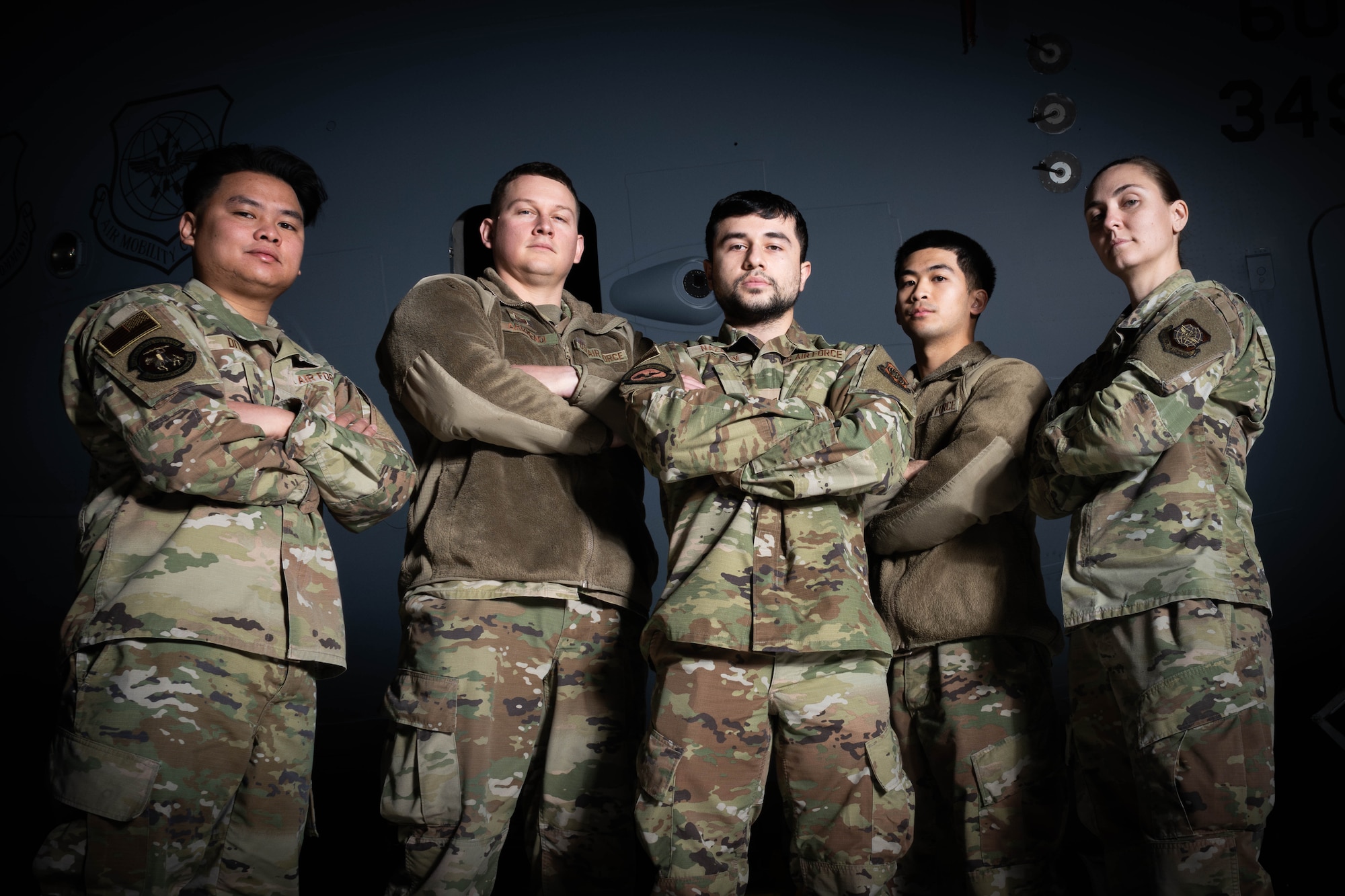 A group of Airman stand together with their arms crossed
