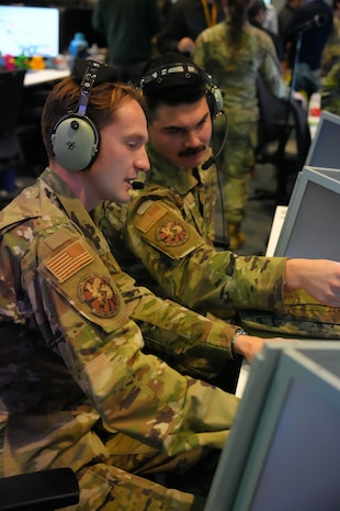 photo of military members working computers wearing headsets