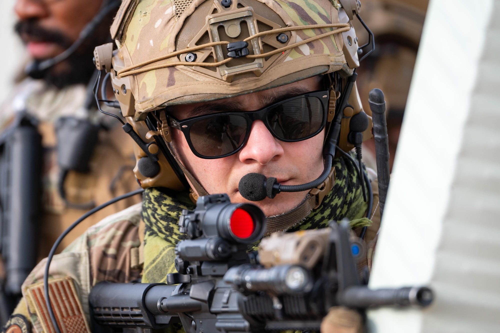 A man in uniform points his weapon.