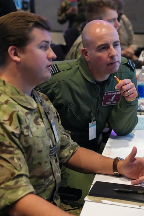 photo of Two United Kingdom members work on computers