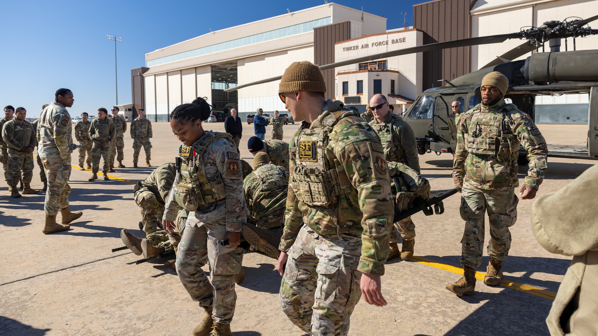 Airmen carrying patient litter away from helicopter