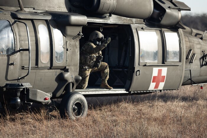 Man in helicopter motioning for people to approach