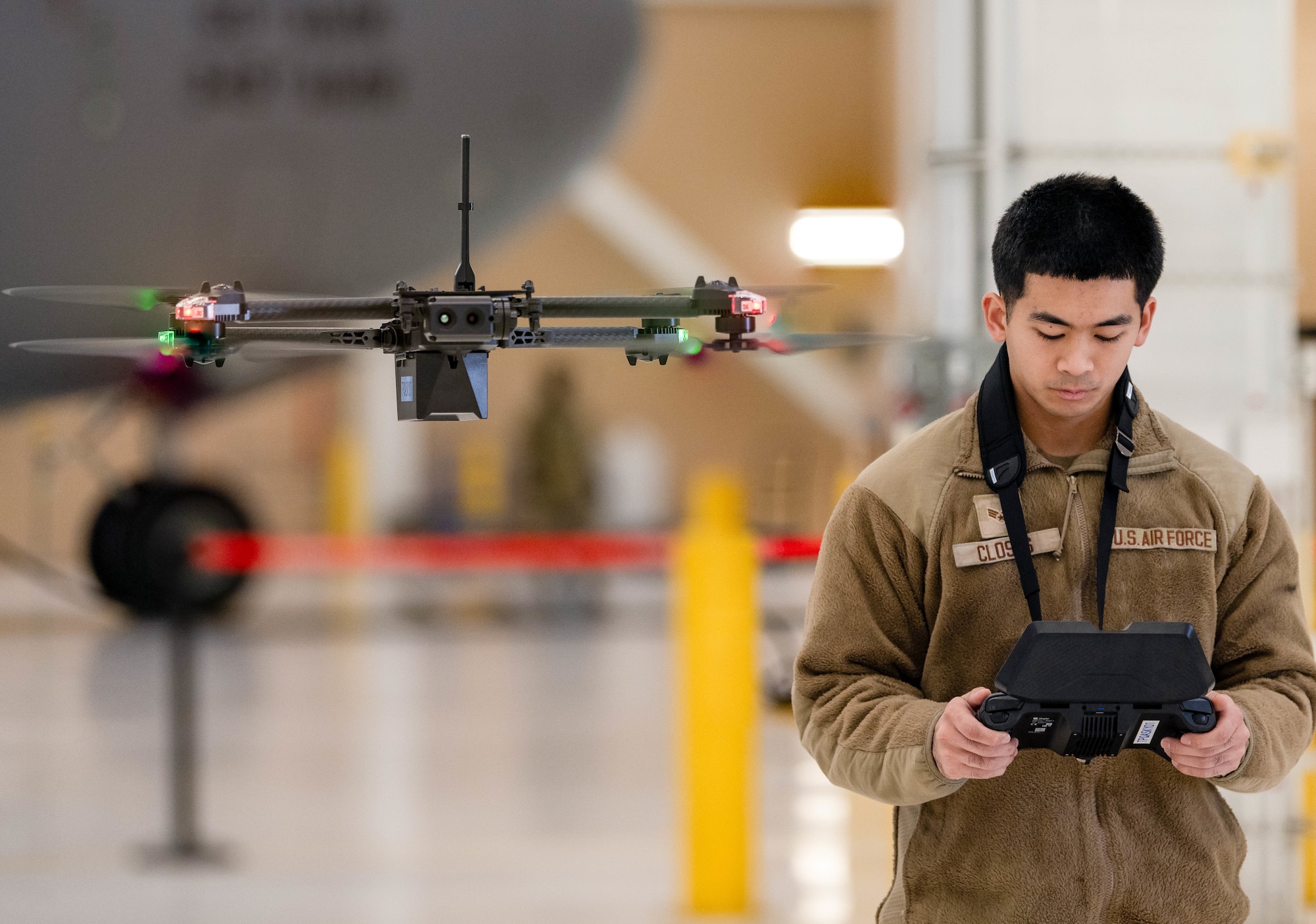 An Airman flies a drone in a hangar