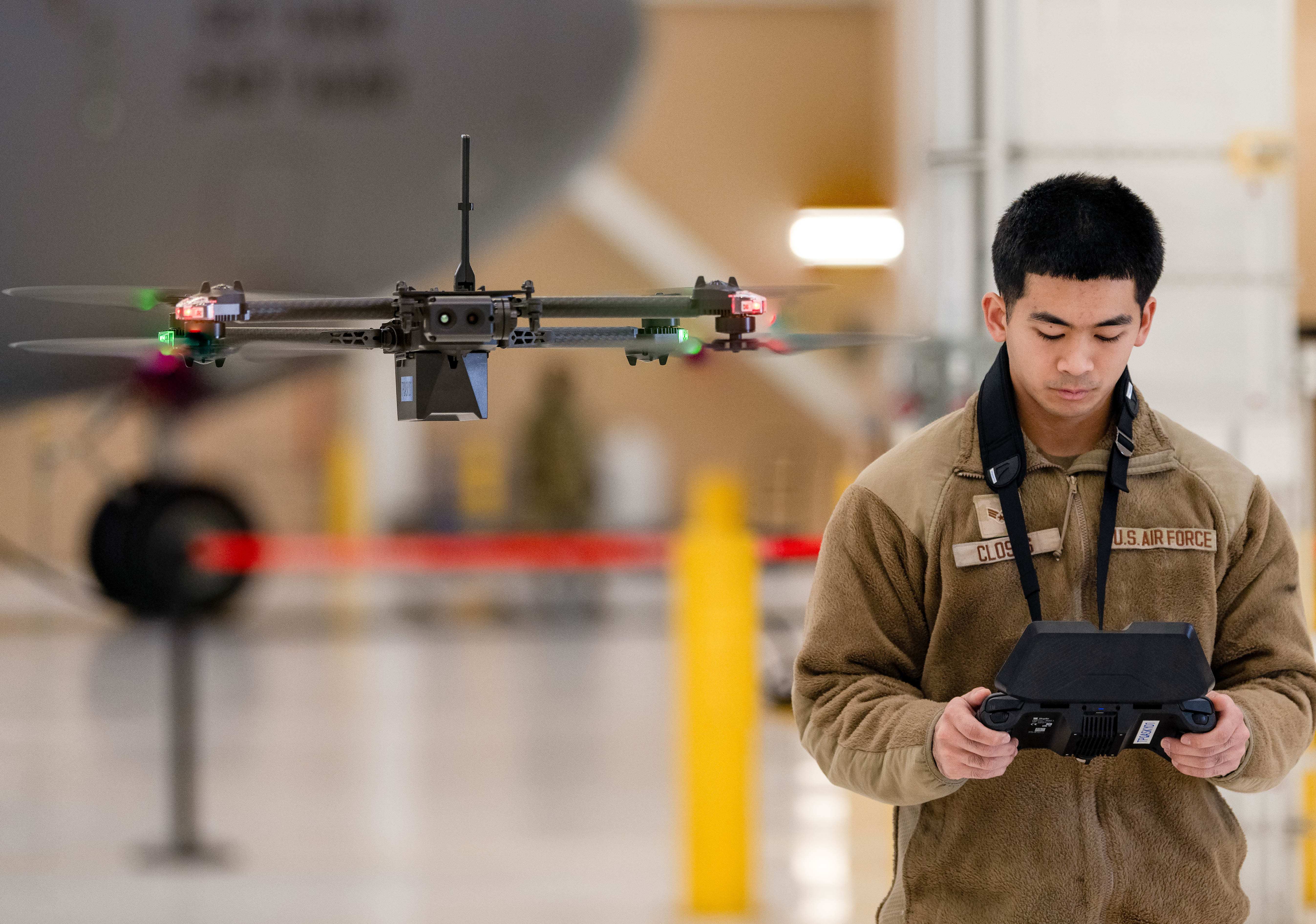 An Airman flies a drone in a hangar