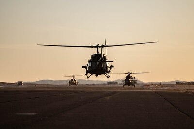 A helicopter lands at sunset.