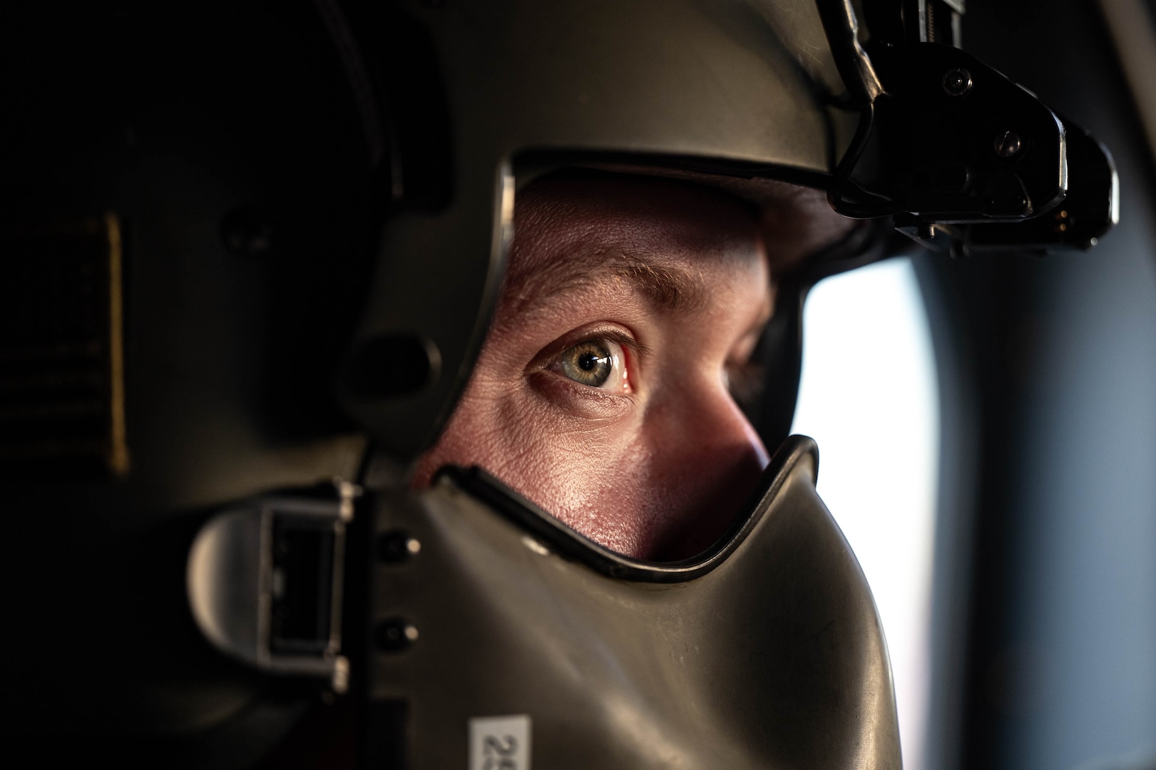 A flight engineer wears his helmet.