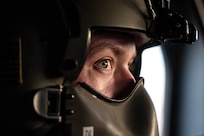 A flight engineer wears his helmet.
