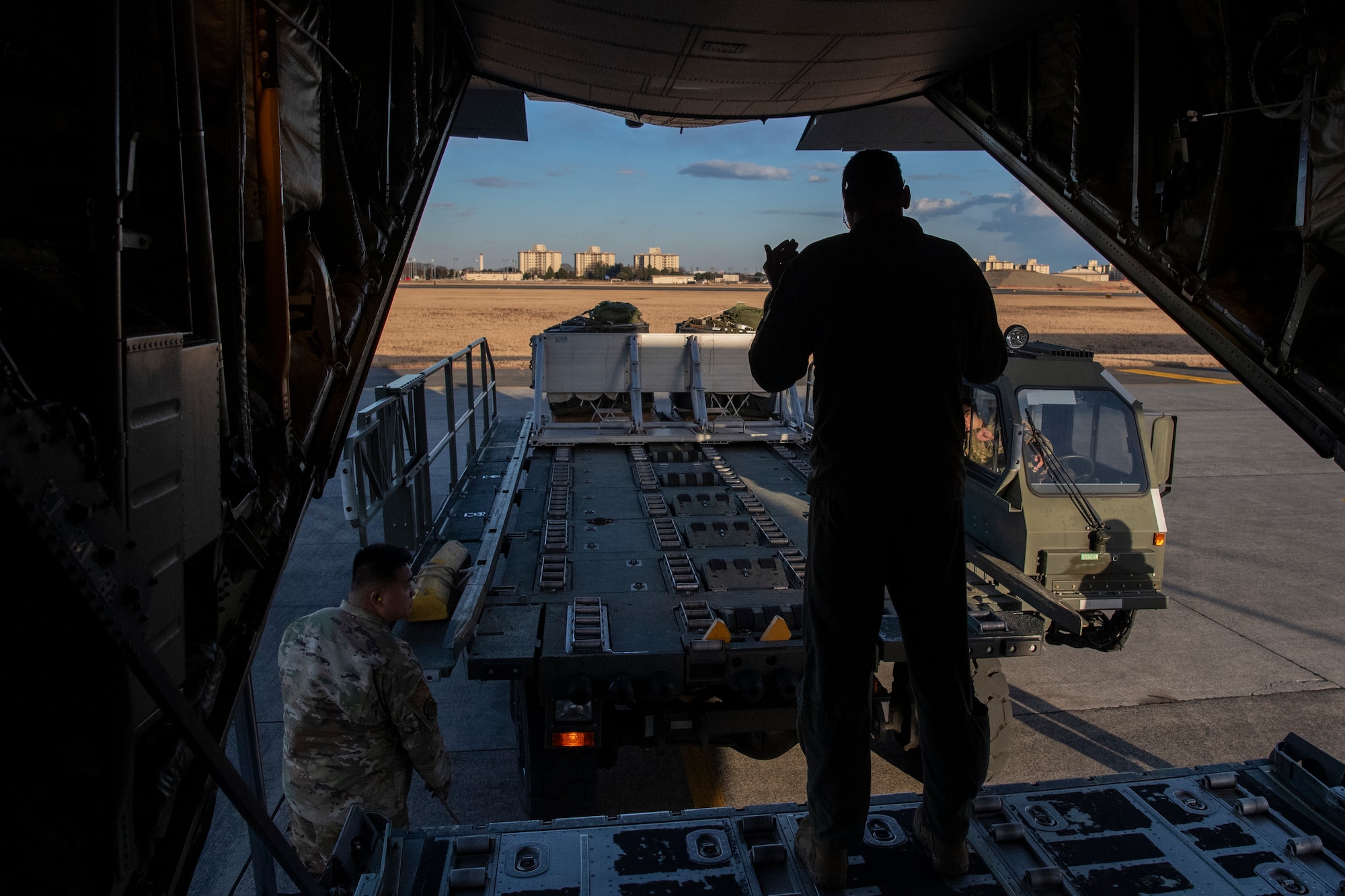 An airman marshals a Turner 60k aircraft cargo loader.