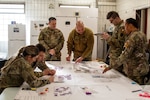 U.S. Soldiers with the Headquarters and Headquarters Company, 56th Stryker Brigade Combat Team, 28th Infantry Division, Pennsylvania National Guard in support of the Joint Multinational Training Group-Ukraine mission play through the role of medics providing treatment during a mass casualty triage wargame exercise at Grafenwoehr Training Area, Germany, Jan. 22, 2025.  The wargame addresses casualty care triage in a large-scale combat operations environment.