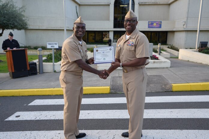 Captain TaRail A. Vernon presents Lieutenant Foster Boadi with the Lean Six Sigma Green Belt Certification