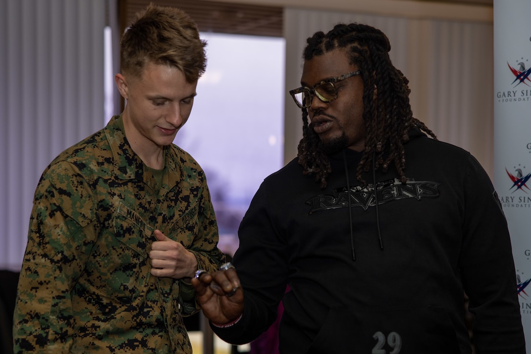 U.S. Marine Corps Cpl. Brandon Manifold, a motor vehicle operator with Security Battalion, talks about rings with Derrick Martin, a two time super bowl Champion and National Football League (NFL) Alumnus of the Green Bay Packers and the New York Giants on Marine Corps Base Quantico, February 6, 2025. Members of the NFL visited Quantico to meet service members and foster morale. (U.S. Marine Corps photo by Lance Cpl. Federico Marquez)