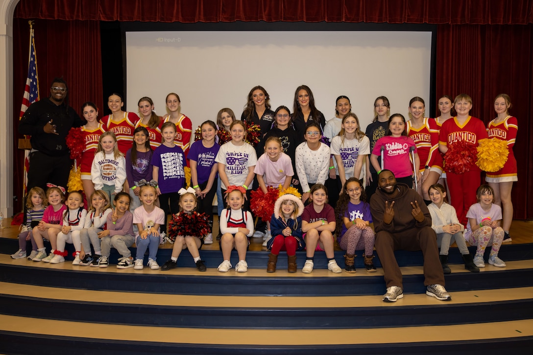 Kids of the Crossroads Elementary School take a group photo with Athletes of the National Football League (NFL) on Marine Corps Base Quantico, February 6, 2025. Members of the National Football League visited Quantico to meet service members and foster morale. (U.S. Marine Corps photo by Lance Cpl. Federico Marquez)