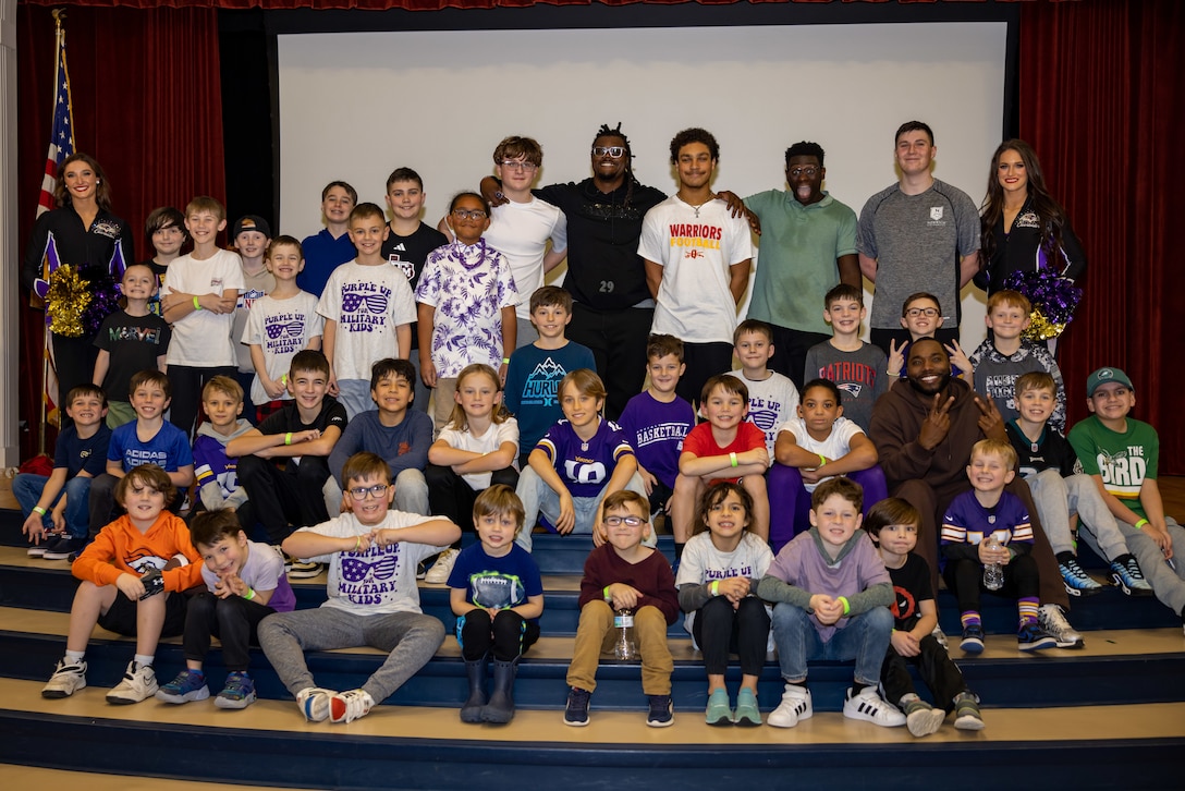 Kids of the Crossroads Elementary School take a group photo with Athletes of the National Football League (NFL) on Marine Corps Base Quantico, February 6, 2025. Members of the National Football League visited Quantico to meet service members and foster morale. (U.S. Marine Corps photo by Lance Cpl. Federico Marquez)