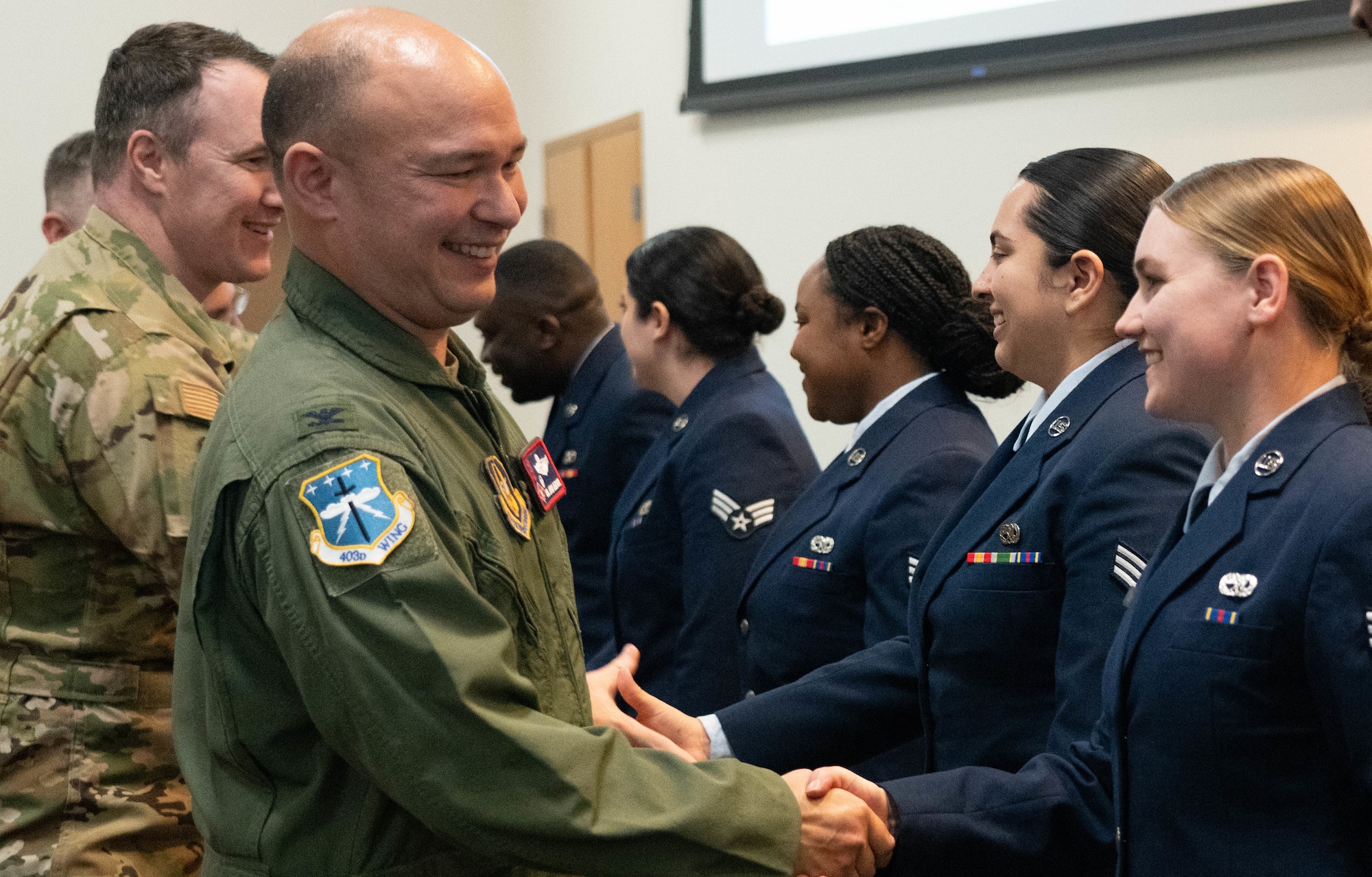 Colonel shaking Airman's hand.