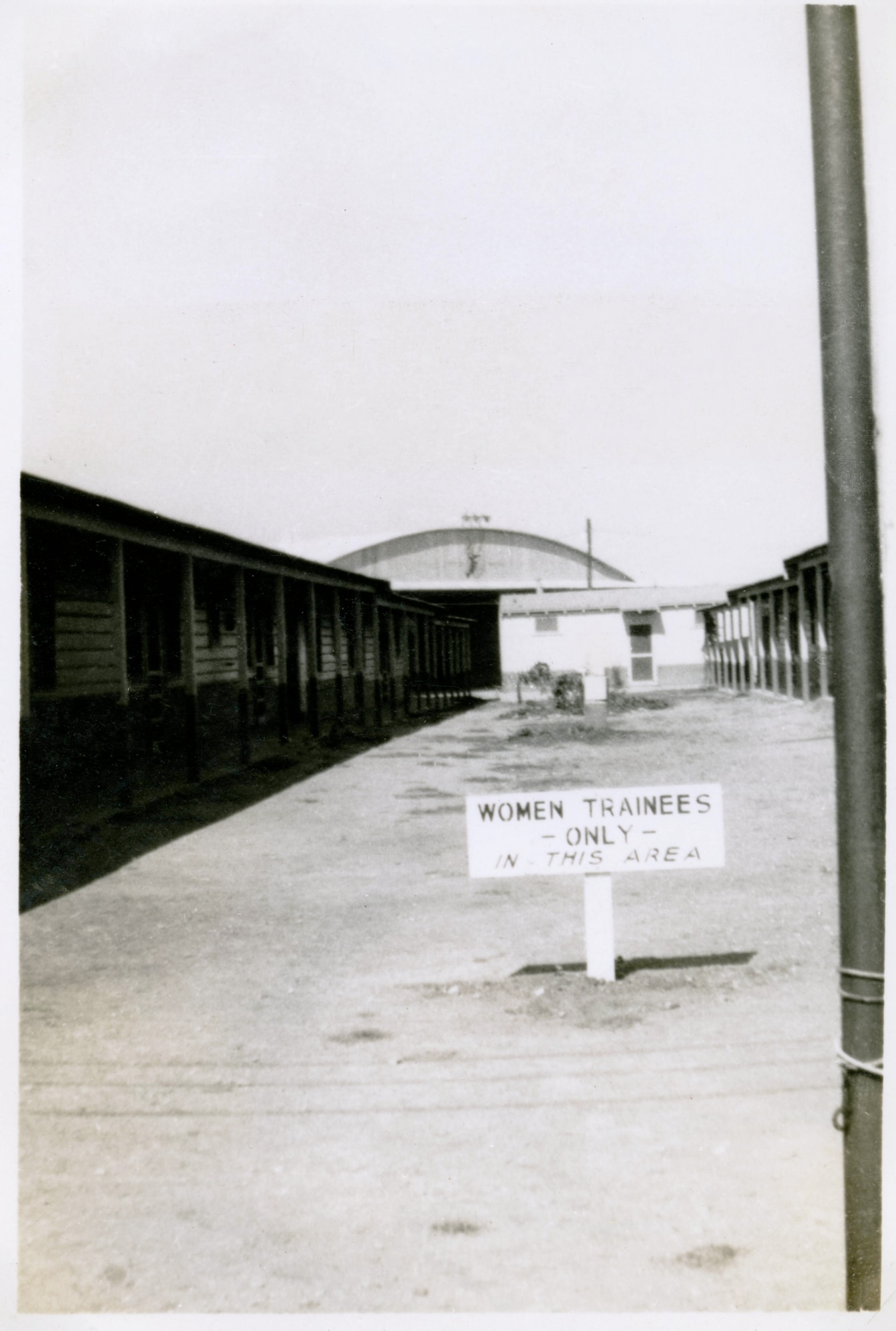 row of barracks with a sign in the middle that states Women Trainees only in this area