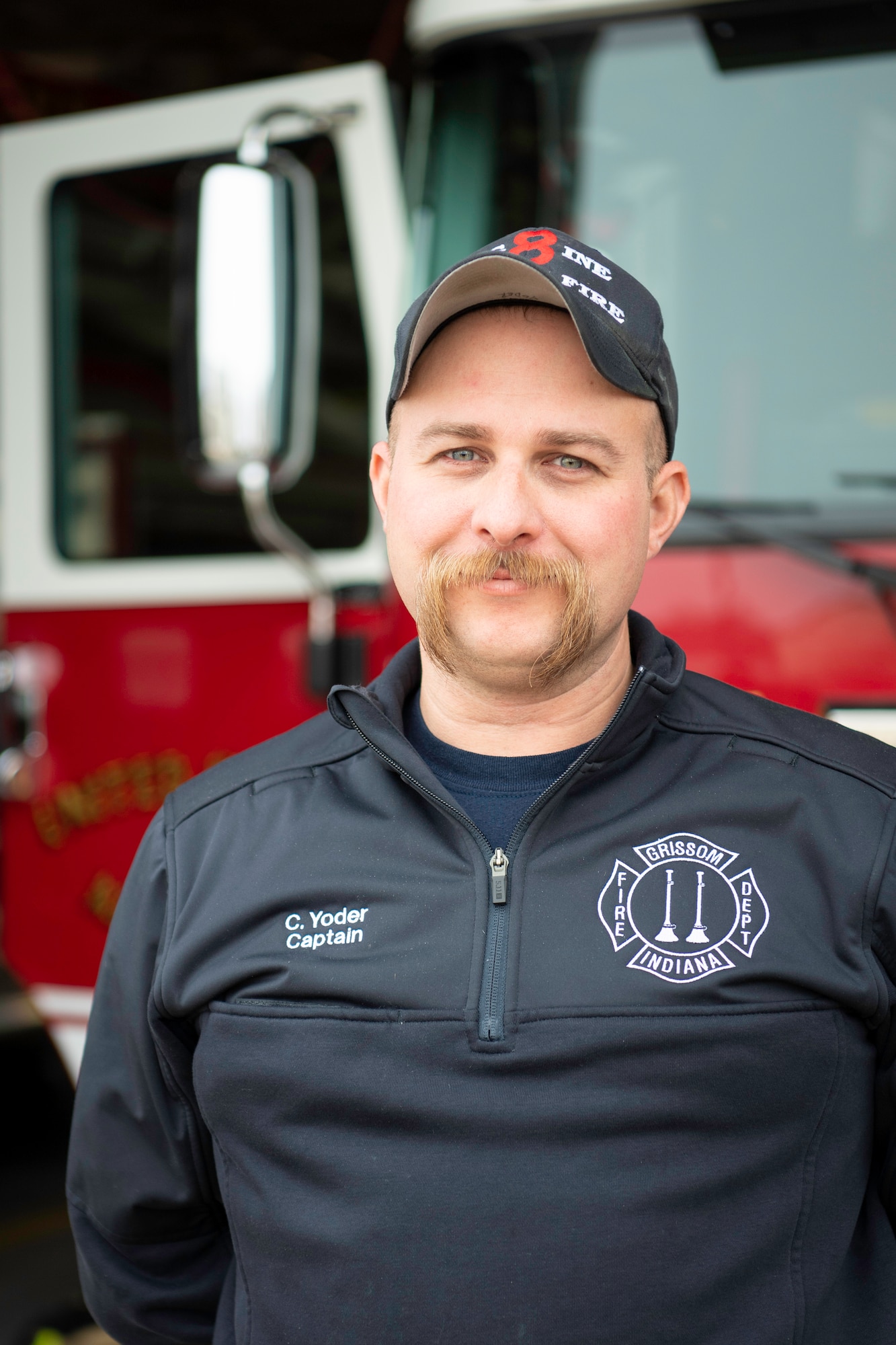 Cameron Yoder, 434th Civil Engineer Squadron firefighter, poses for a photo in front of a fire truck.
