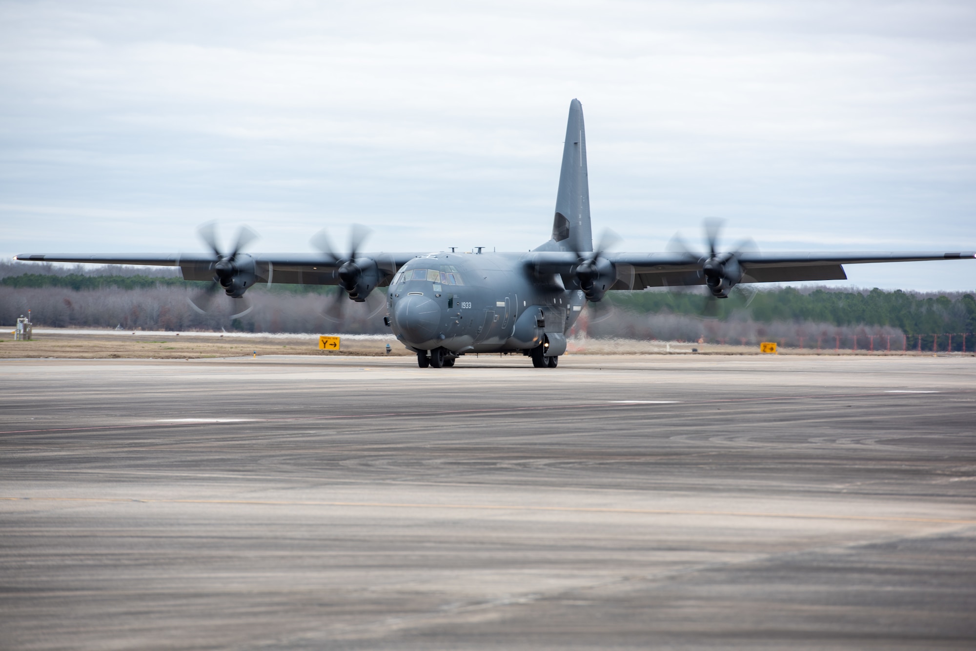 A J-model C-130 assigned to the 189th Airlift Wing taxis down a flightline, its props are spinning.