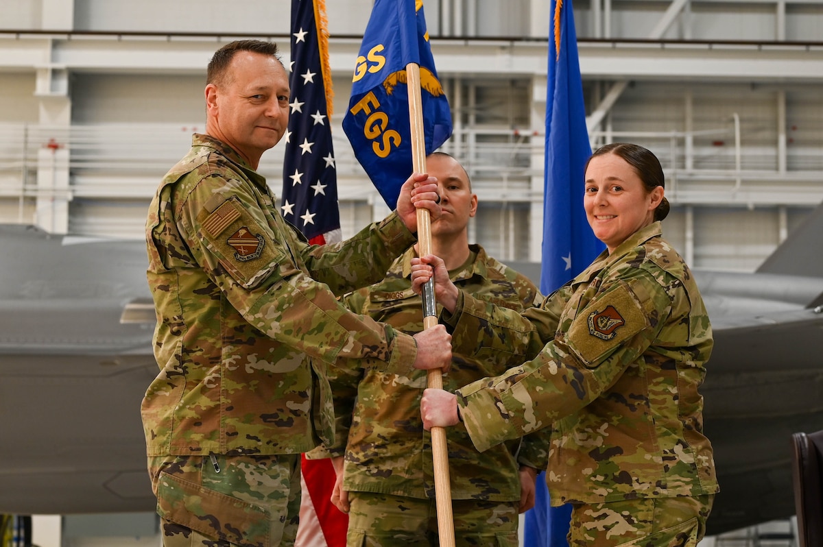 U.S. Air Force Col. Jerrymar Copeland, left, hands the guidon to Maj. Allana Gallant, 355th Fighter Generation Squadron incoming commander, during a change of command ceremony at Eielson Air Force Base, Alaska, Feb. 7, 2025.