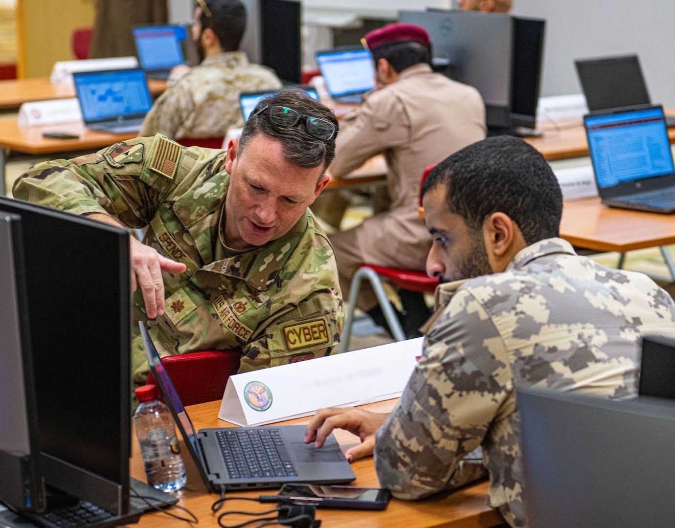 A U.S. Air Force and Qatari Armed Forces service member collaborate to solve a framework issue during a cyber security training at Exercise Eagle Resolve 2025 (ER25) within the U.S. Central Command area of responsibility on Jan. 13, 2025. The training is designed to help participants improve interoperability between the U.S. military and Gulf nation forces by enhancing communication, aligning operational strategies, and fostering joint responses to shared security challenges. (U.S. Air Force photo by Senior Airman Sir Wyrick)