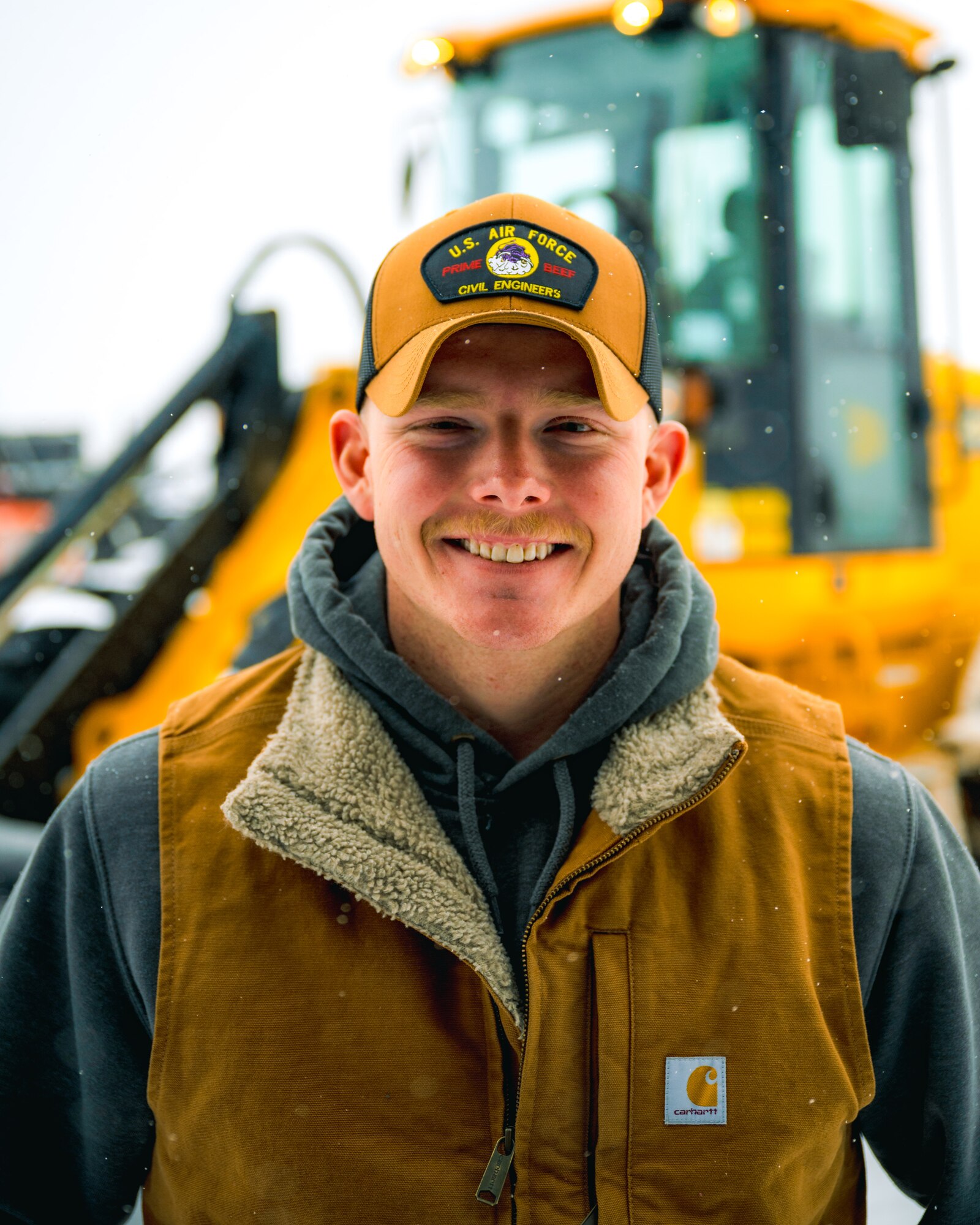 Airman 1st Class Levi Phillips, 90th Civil Engineer Squadron Horizontal Repair Shop pavements and construction equipment journeyman, poses for a photo infront of a front end loader at F.E. Warren Air Force Base, Wyoming, Jan. 25, 2025. The 90 CES Horizontal Repair Shop, also known as the ‘Dirt Boyz’, removes snow from base roads and key infrastructure, ensuring unimpeded access to missile alert facilities and launch control centers that support the 90th Missile Wing’s nuclear deterrence mission. (U.S. Air Force photo by Staff Sgt. Michael A. Richmond)