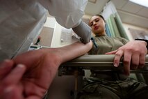 Senior Airman Eliana Vales, 5th Medical Operations Squadron laboratory technician, draws blood from Senior Airman Alyssa Bankston, 5th Bomb Wing public affairs specialist, at Minot Air Force Base, North Dakota, Jan. 29, 2025. Laboratory technicians are responsible for drawing blood and conducting chemistry examinations. (U.S. Air Force photo by Airman 1st Class Wesley Davies)