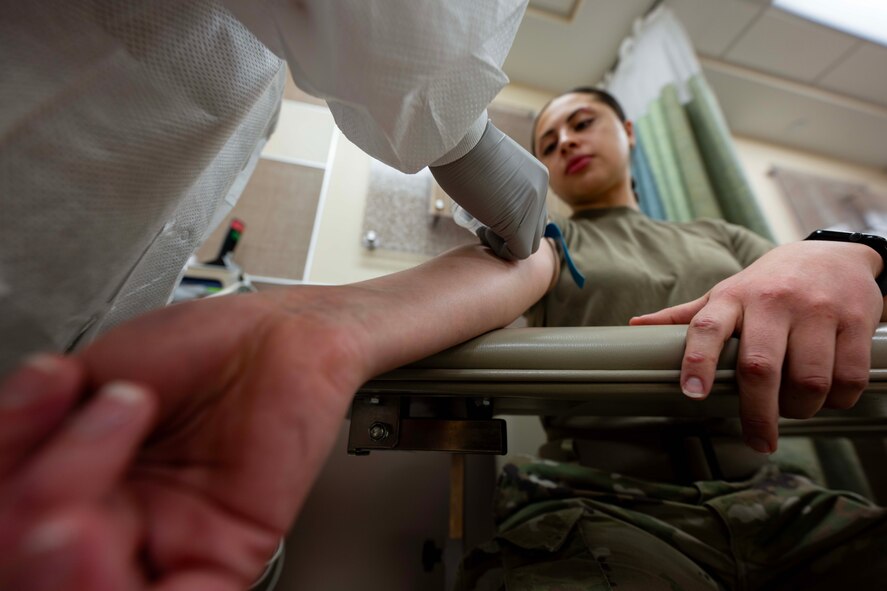 Senior Airman Eliana Vales, 5th Medical Operations Squadron laboratory technician, draws blood from Senior Airman Alyssa Bankston, 5th Bomb Wing public affairs specialist, at Minot Air Force Base, North Dakota, Jan. 29, 2025. Laboratory technicians are responsible for drawing blood and conducting chemistry examinations. (U.S. Air Force photo by Airman 1st Class Wesley Davies)
