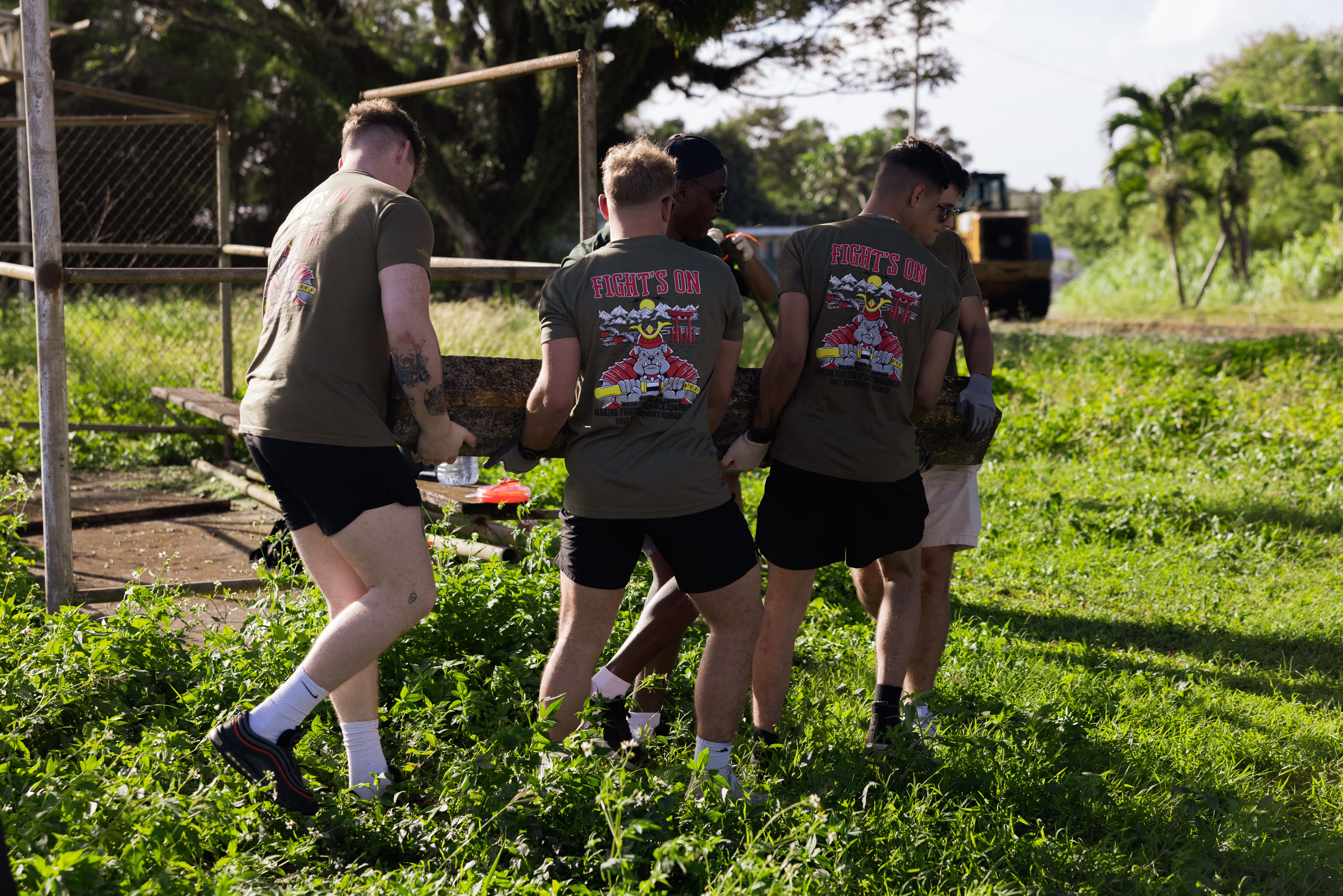 U.S. Marines and Sailors with Marine Fighter Attack Squadron 312, Marine Aircraft Group 31, 2nd Marine Air Wing, lift a stone during a volunteer event at Yona, Guam, Jan. 25, 2025. The U.S. Marines recently assisted the community of Yona by organizing a cleanup of one of the local baseball fields; this collaborative effort highlighted their commitment to supporting the local community beyond their primary duties. (U.S. Marine Corps photo by Cpl. Brayden Daniel)