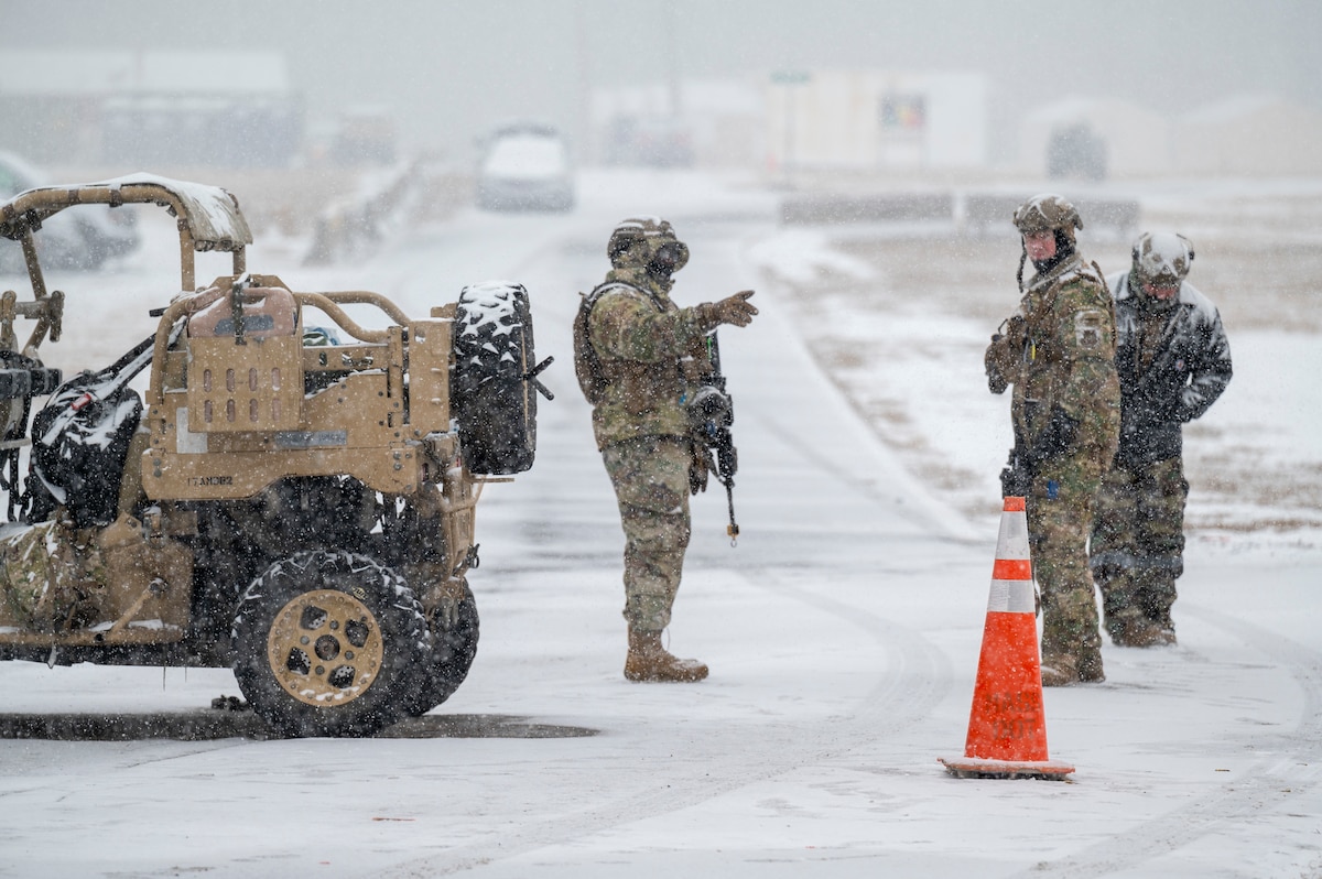 Airmen guarding an entry control point in the snow