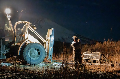 An airman directs a forklift.