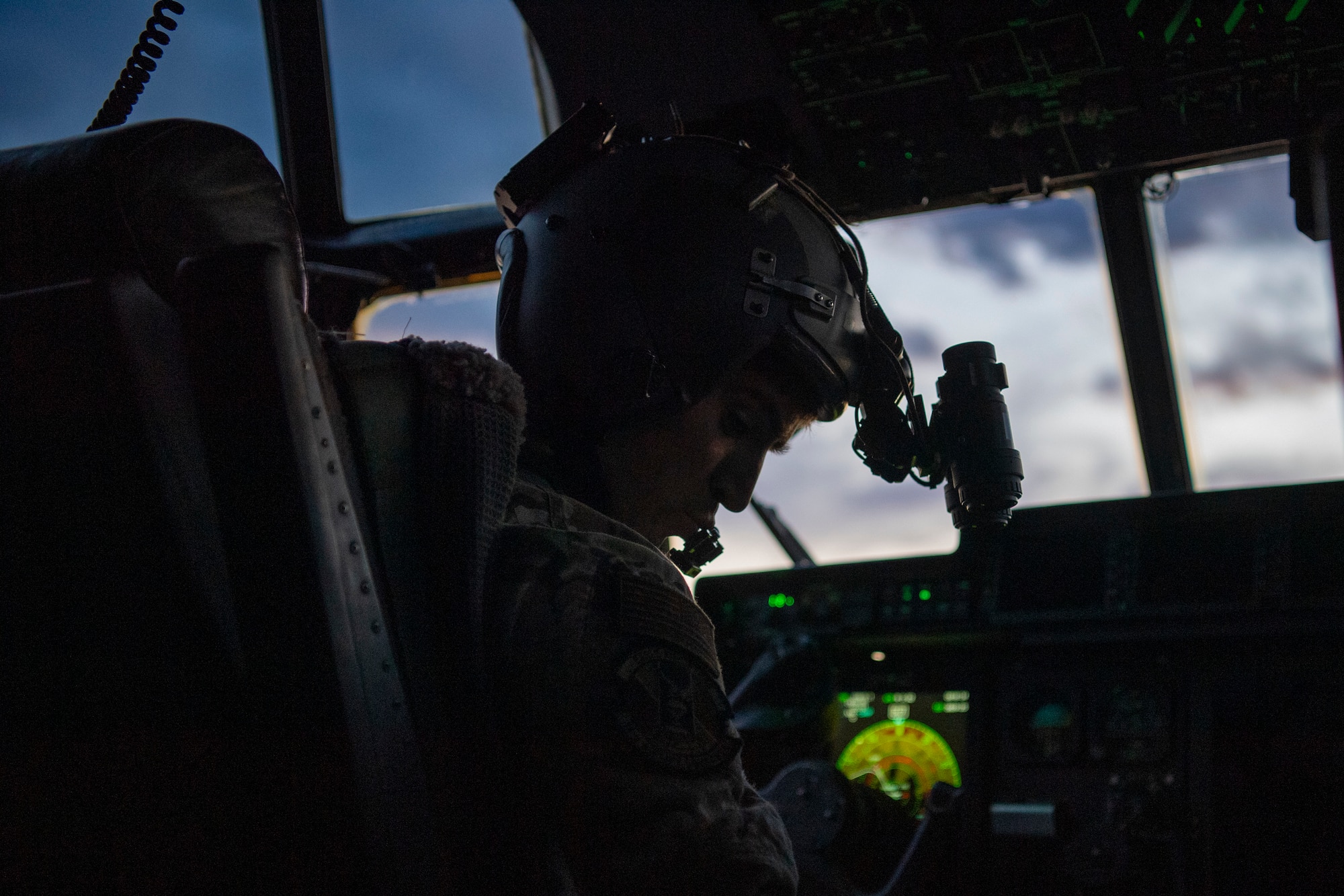 An airman preforms a pre-flight check in the cockpit of a C-130J Super Hercules