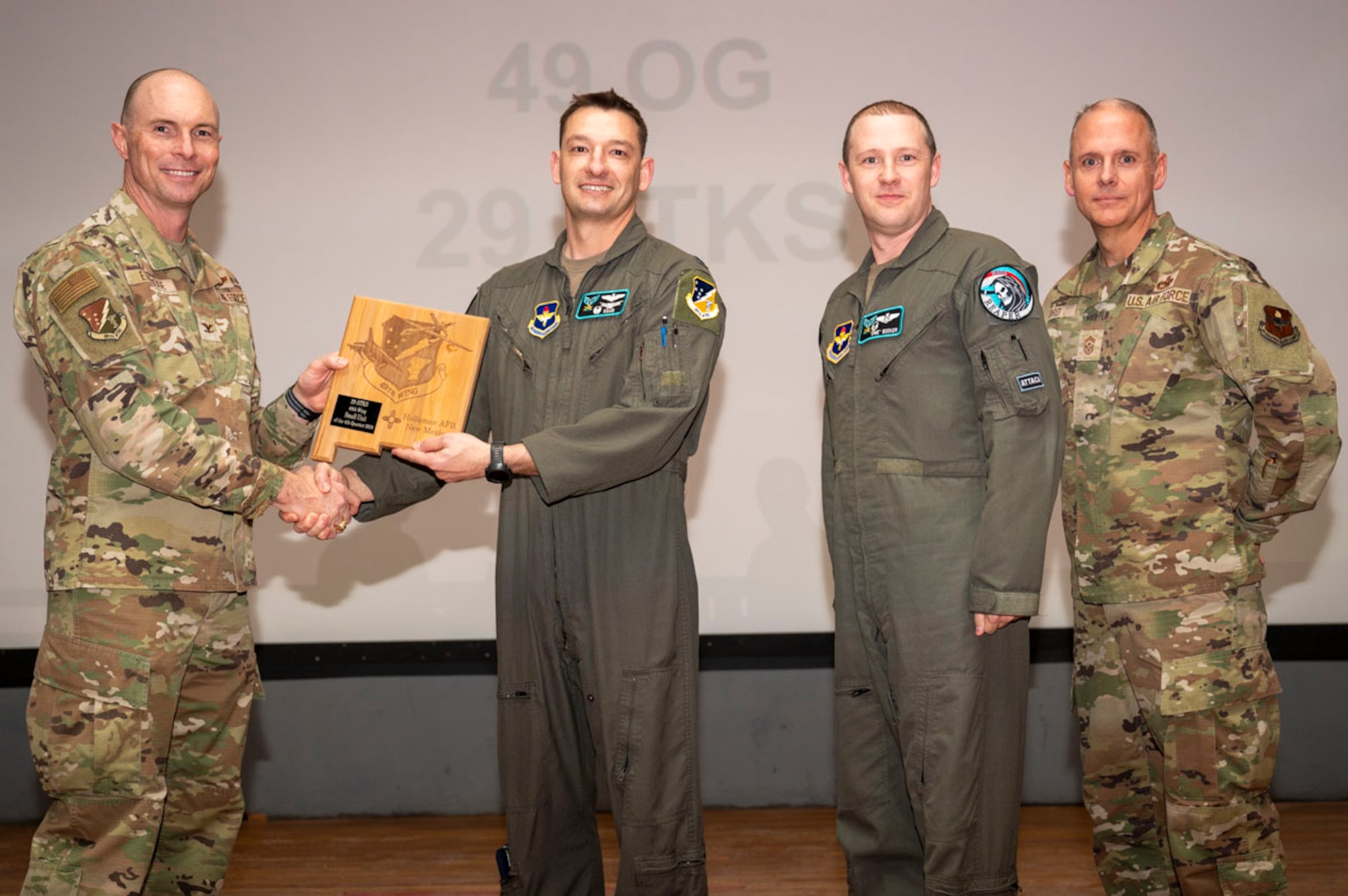 U.S. Air Force Lt. Col. Brandon Taylor, 29th Attack Squadron commander U.S. Air Force Master Sgt. Nicolas Booker, 29th ATKS senior enlisted leader, accepts the 49th Wing’s Small Unit of the Quarter Award, during the 49th Wing’s 4th Quarter Award ceremony at Holloman Air Force Base, New Mexico, Feb. 7, 2025. Quarterly award winners were selected based on their technical expertise, demonstration of leadership and job performance. (U.S. Air Force photo by Senior Airman Michelle Ferrari)