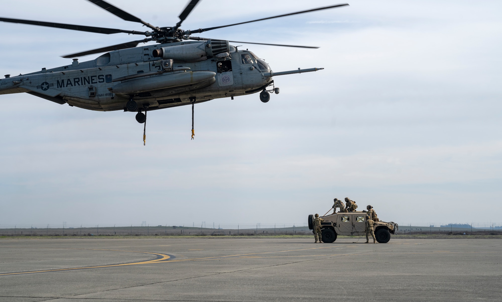 Helicopter prepares to external lift Humvee
