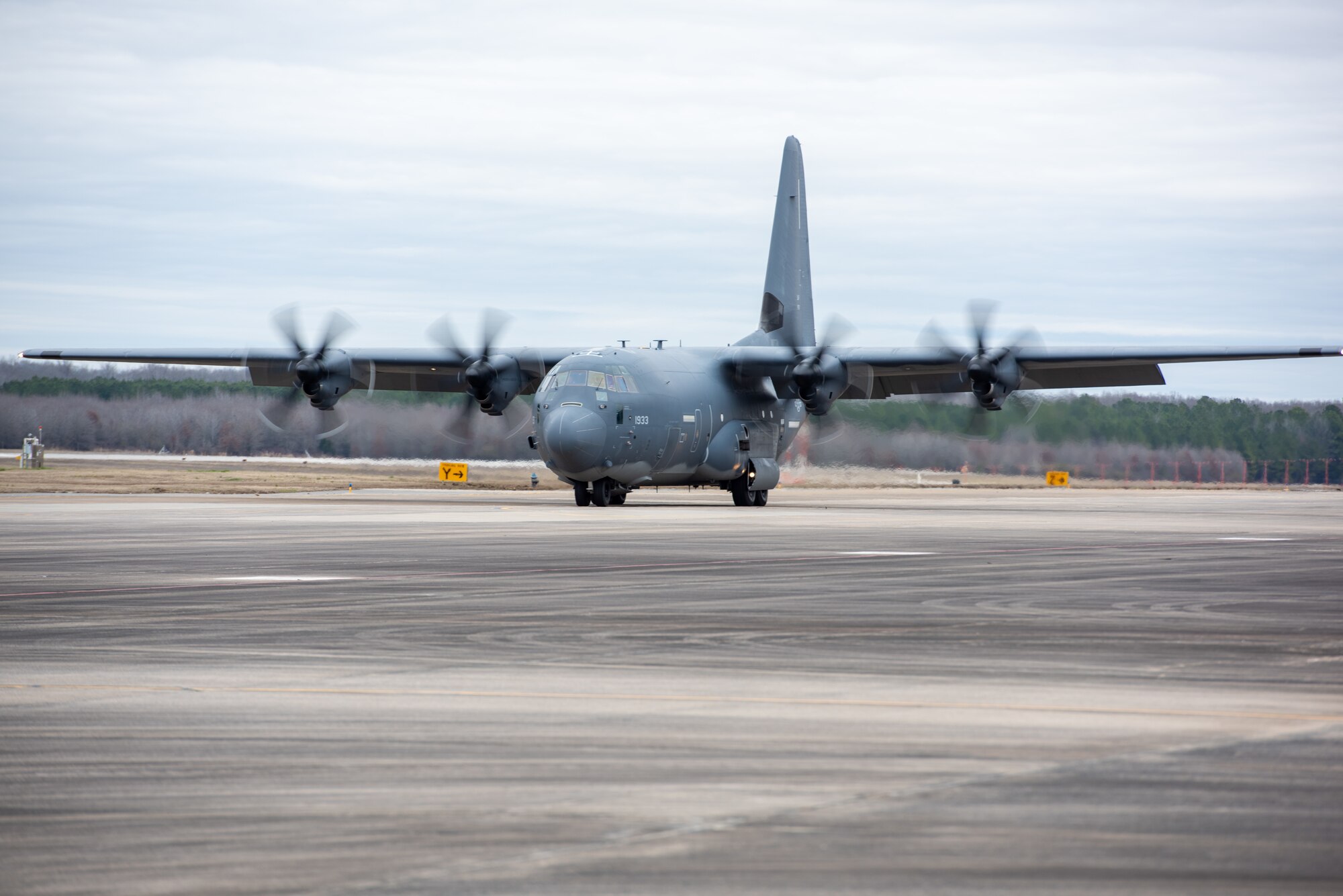 A J-model C-130 assigned to the 189th Airlift Wing taxis down a flightline, its props are spinning.