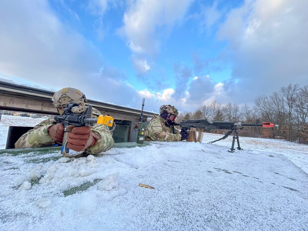 Two Airmen aiming their weapon