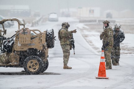 Airmen guarding an entry control point in the snow