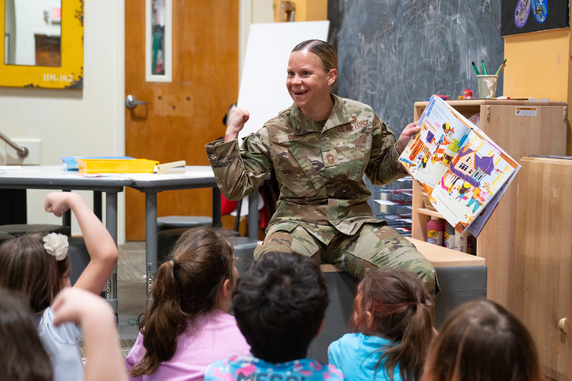 U.S. Air Force Chief Master Sergeant Karissa L. Gunter, Space Launch Delta 45 Senior Enlisted Airman, reads a book to a group of children.