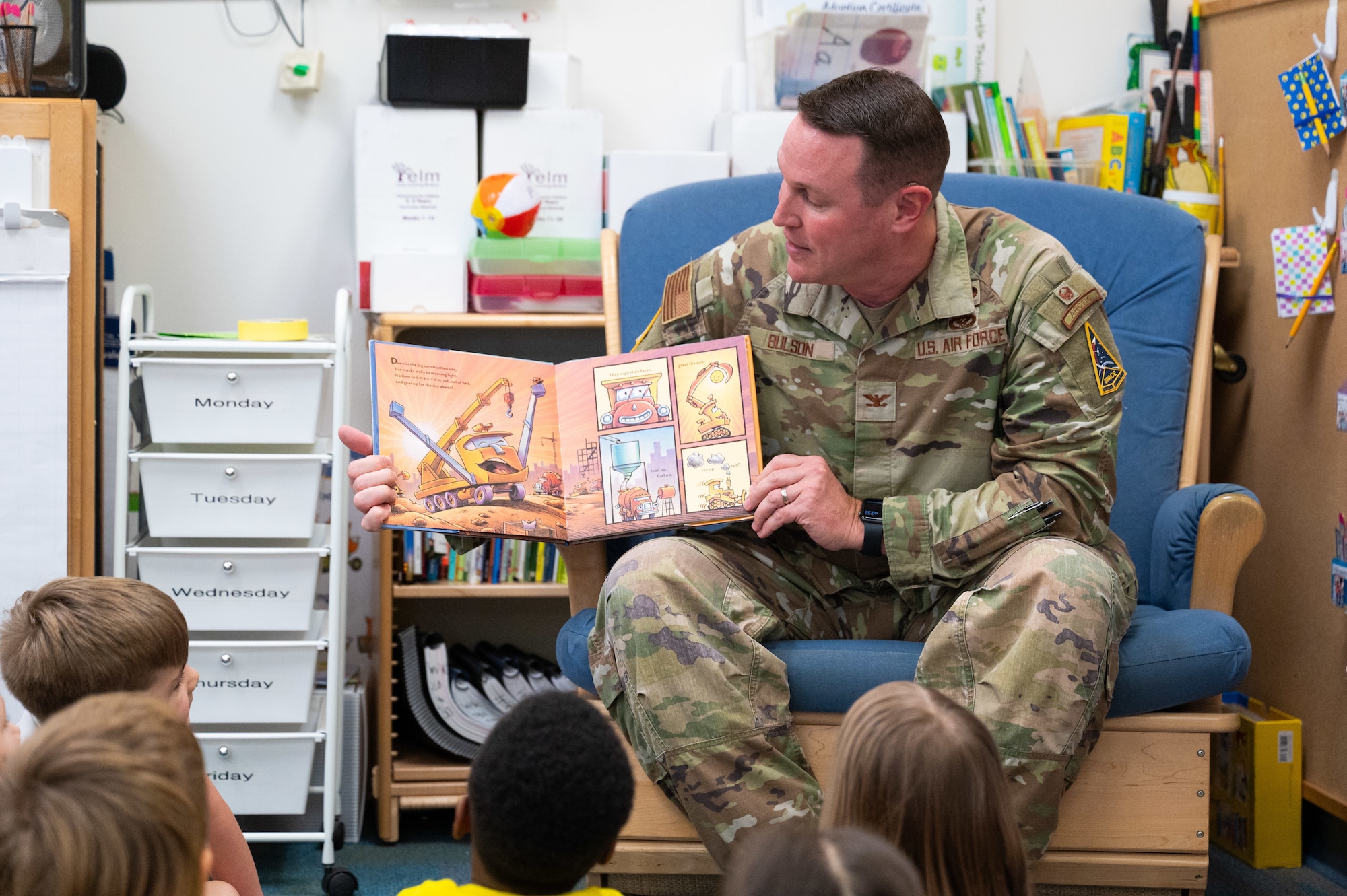 U.S. Space Force Col. Christopher Bulson, Space Launch Delta 45 deputy support commander, reads a book to a group of children.