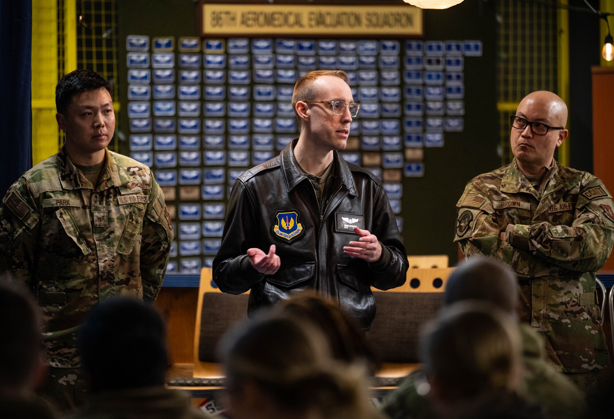 U.S. Air Force Staff Sgt. Jooho Park, 86th Aeromedical Evacuation Squadron technician, U.S. Air Force Master Sgt. Brian McGinnis, 86th AES flight chief of operations, and U.S. Air Force Maj. James Brown, 86th Medical Squadron Critical Care Air Transport Team nurse, brief participants of the 68T Army Symposium annual training about the mission of the 86th AES at Ramstein Air Base, Germany, Feb. 5, 2025. The symposium took place from Feb. 3-7, 2025. This was the first symposium that incorporated the CCATT, 86th AES and animal care specialists, providing familiarity for the service members on the entire continuum of care for a military working dog. (U.S. Air Force photo by Senior Airman Jared Lovett)