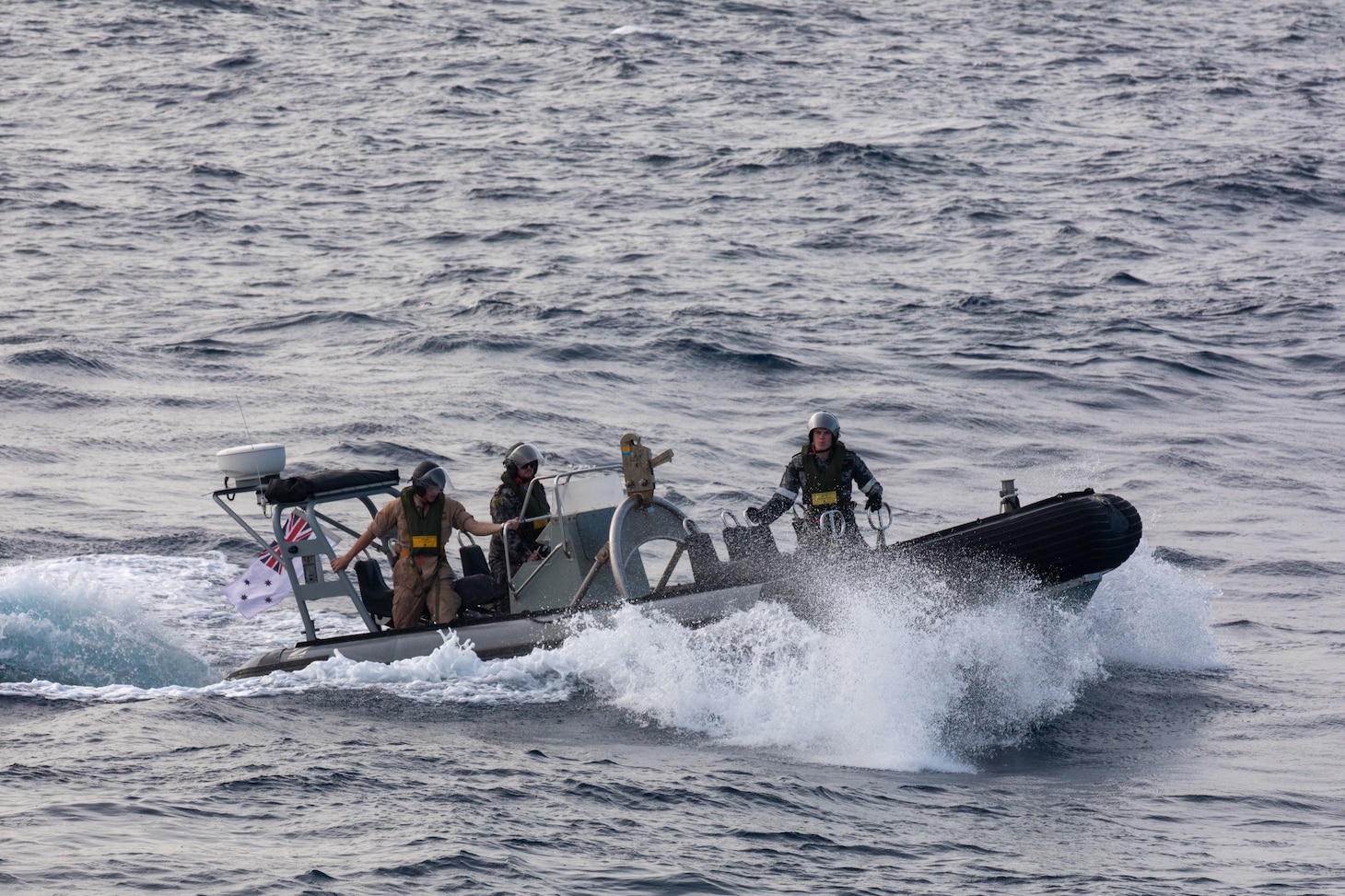 SOUTH CHINA SEA (Feb. 6, 2025) Lt. j. g. Peter Greenbaum, assigned to the Arleigh Burke-class guided-missile destroyer USS Benfold (DDG 65), and Australian Navy Sailors guide a Zodiac Mark 2 Grand Raider general purpose inflatable boat toward USS Benfold during multilateral operations with Australia and the United Kingdom in the South China Sea, Feb. 6. Benfold is forward deployed and assigned to Destroyer Squadron (DESRON) 15, the Navy’s Largest DESRON and U.S. 7th Fleet’s principal surface force. (U.S. Navy Photo by Mass Communication Specialist 2nd Class Monica Walker.)