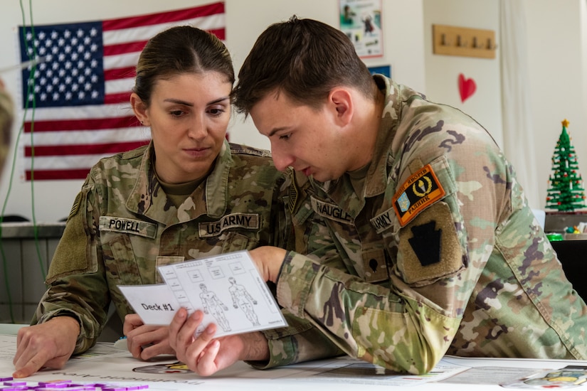 U.S. Army Spc. Karlee Powell and Spc. Caleb Naugle, both combat medic specialists with the 56th Stryker Brigade Combat Team, 28th Infantry Division, Pennsylvania National Guard in support of the Joint Multinational Training Group-Ukraine mission, play through the role of medics providing treatment during a mass casualty triage wargame at Grafenwoehr Training Area, Germany, Jan. 22, 2025.