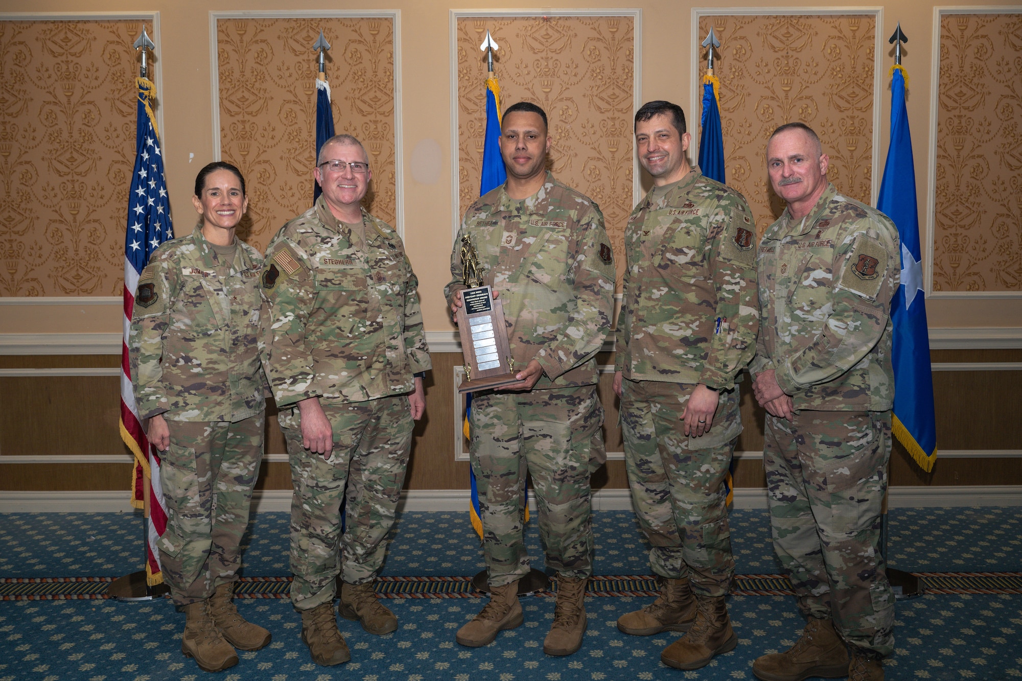 Group of 5 Airmen with center holding Adjutant General's Innovation award.