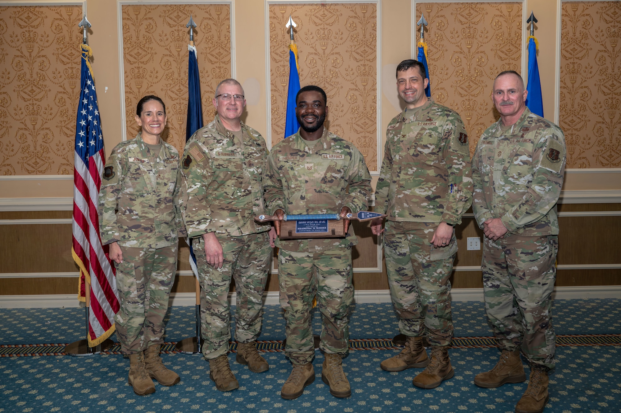 Group of 5 Airmen with center holding Top III Tip of the Spear Award