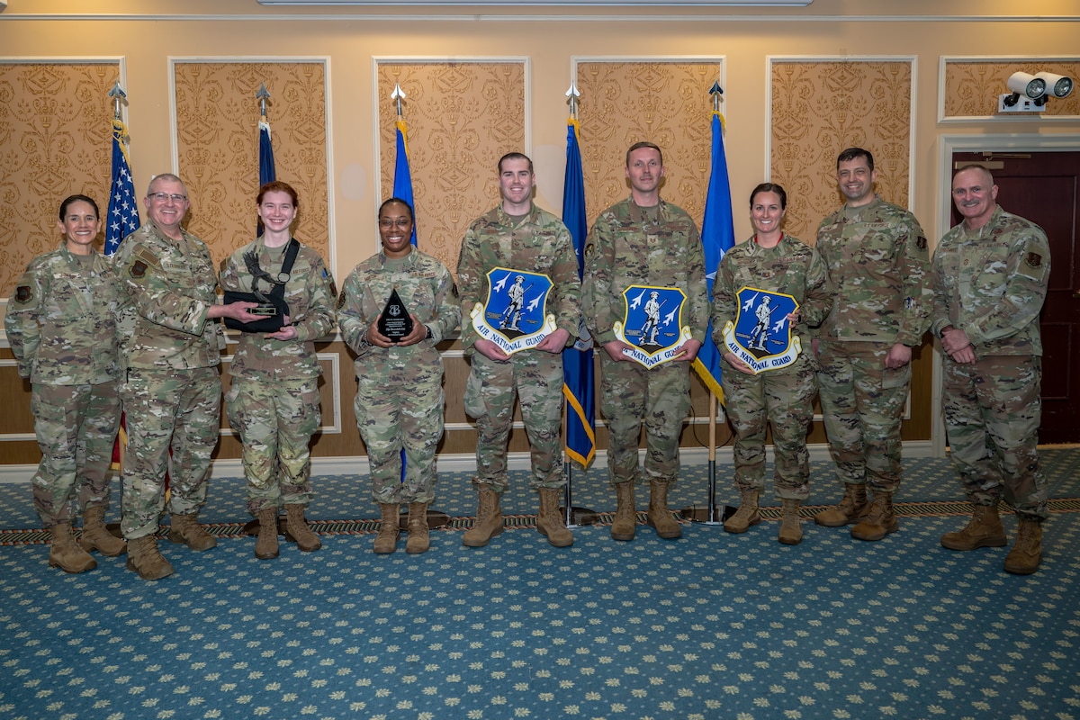 Group of 9 Airmen with center 5 holding various awards